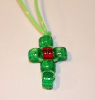 a green necklace with a red and green bead hanging from it's end