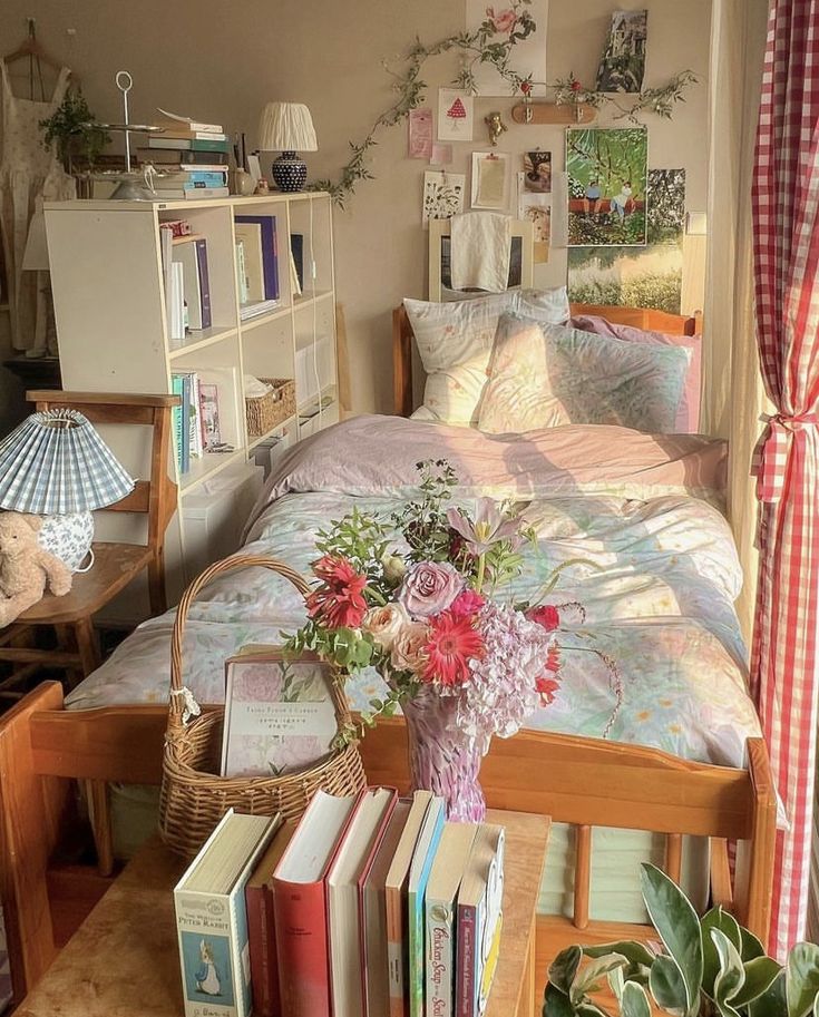 a bedroom with a bed, books and flowers on the table