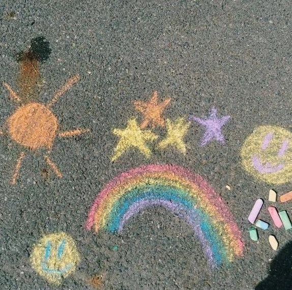 some chalk drawings are on the ground with crayons