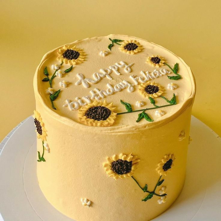 a birthday cake decorated with sunflowers on a plate