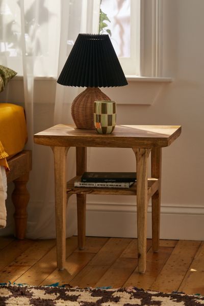 a small wooden table with a lamp on it