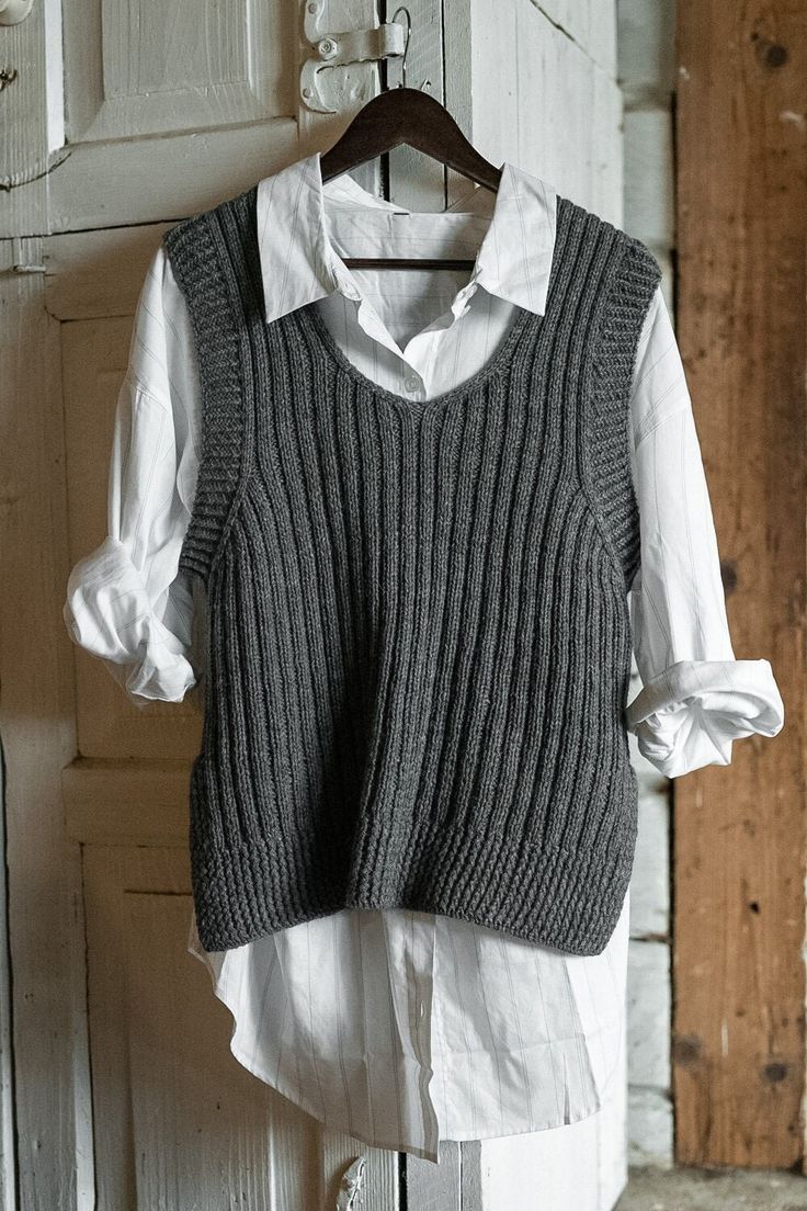 an old sweater vest hanging on a clothes hanger