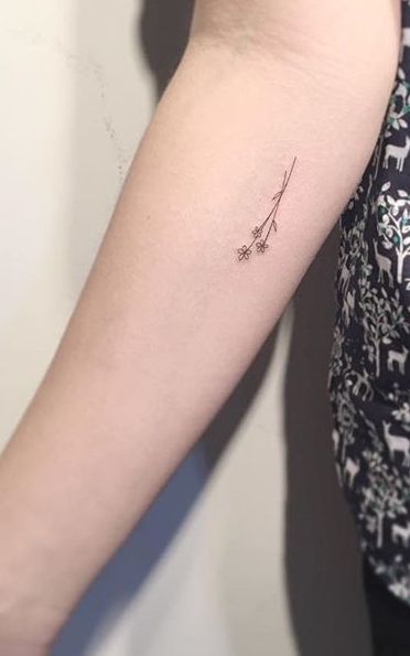 a woman's arm with a single line tattoo on the left side of her arm