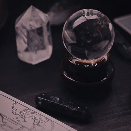 a crystal ball sitting on top of a table next to a pen and ink roller