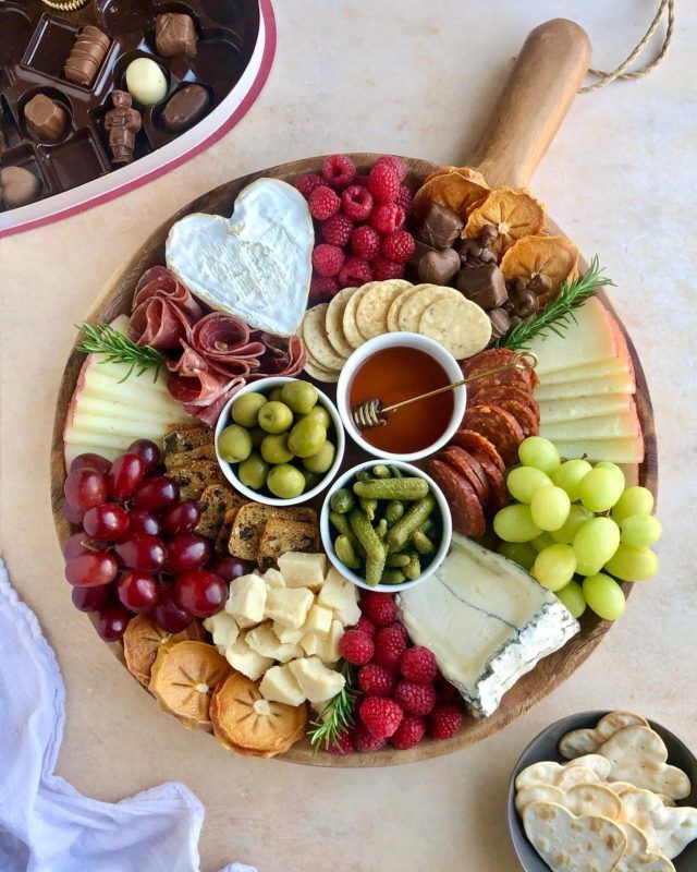 a platter filled with cheese, crackers and fruit