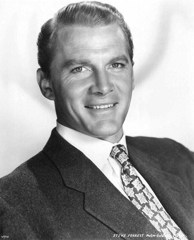 an old black and white photo of a man in a suit smiling for the camera