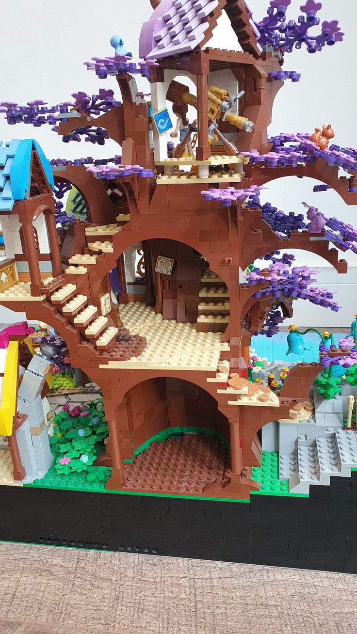 a large lego castle with lots of purple flowers on the roof and trees growing out of it