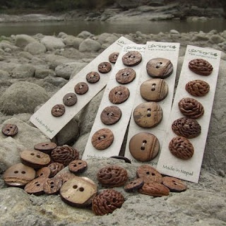 several buttons are laying on some rocks by the water