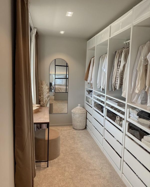 a large walk in closet with white cabinets and drawers