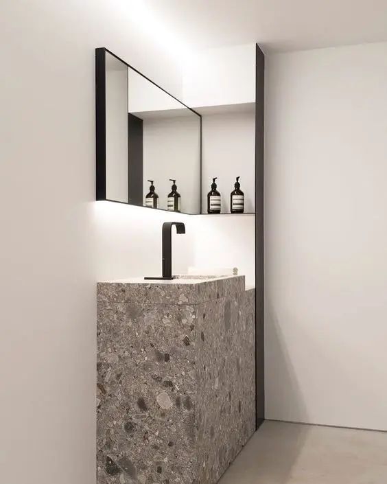 a bathroom sink sitting under a mirror next to a wall