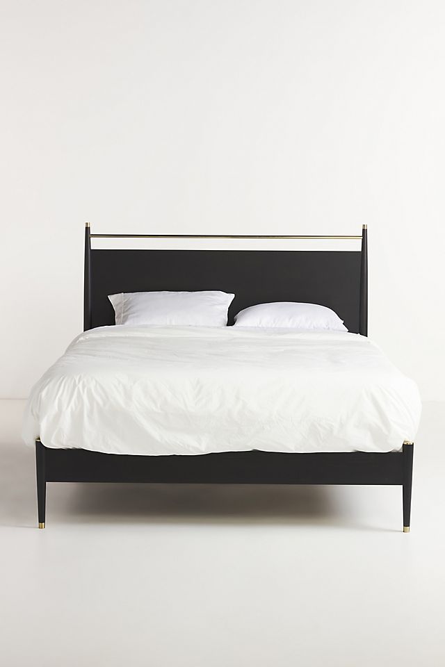 a black bed with white sheets and pillows