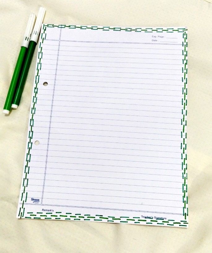 a notepad and pen sitting on top of a sheet of paper with checkered border