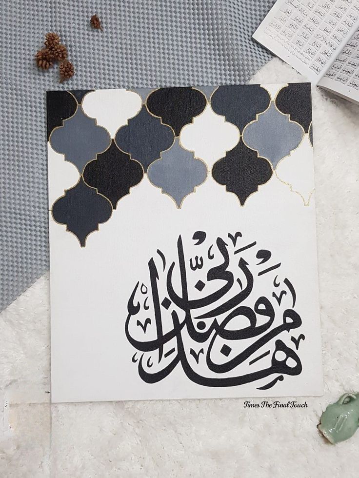 an arabic calligraphy is displayed on a table next to some papers and other items