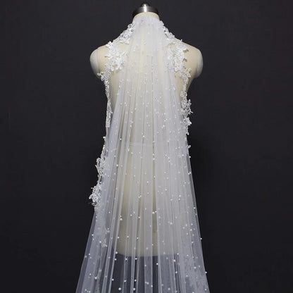 the back of a wedding veil with pearls on it