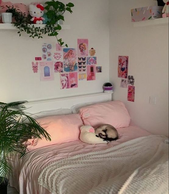 a cat laying on top of a bed next to a plant and potted plant