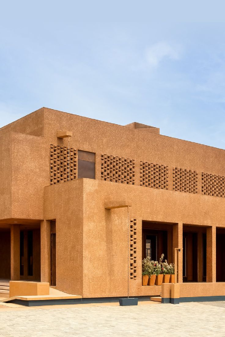 an adobe - style building with planters in the front and side windows on either side