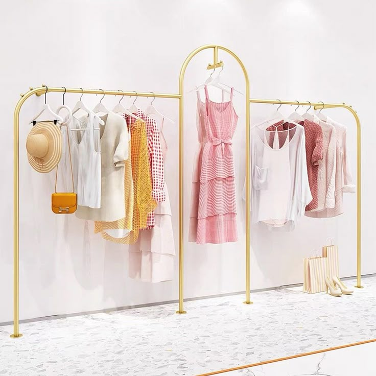 three racks with clothes hanging on them in front of a white wall and marble floor