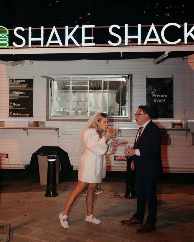 a man and woman standing in front of a food truck