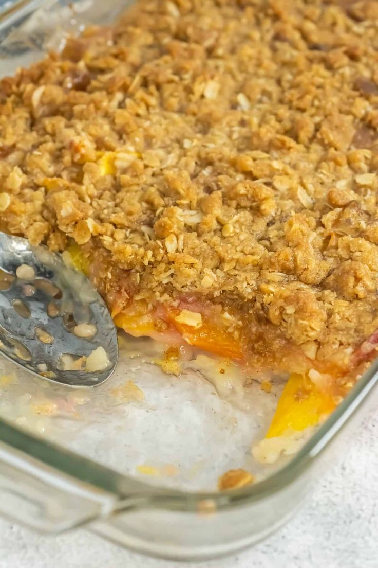 a casserole dish filled with fruit and topped with a crumbled topping