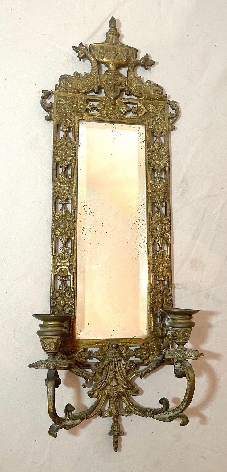 an ornate mirror mounted to the side of a wall