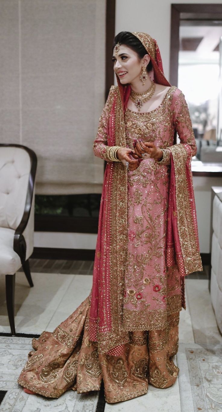 a woman in a pink and gold wedding outfit