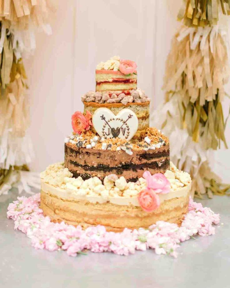 a wedding cake with pink flowers on the bottom and an image of a clock on top