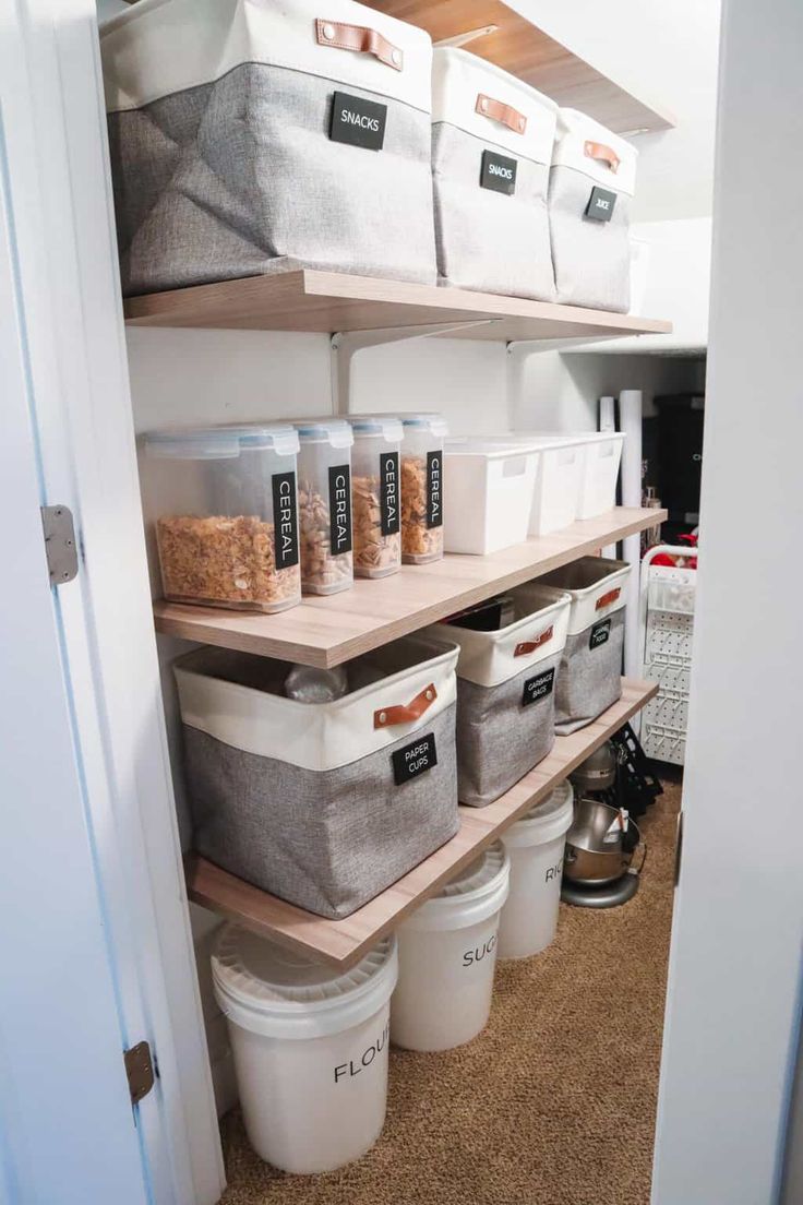 the shelves in this pantry are filled with bins and containers for storage, including food