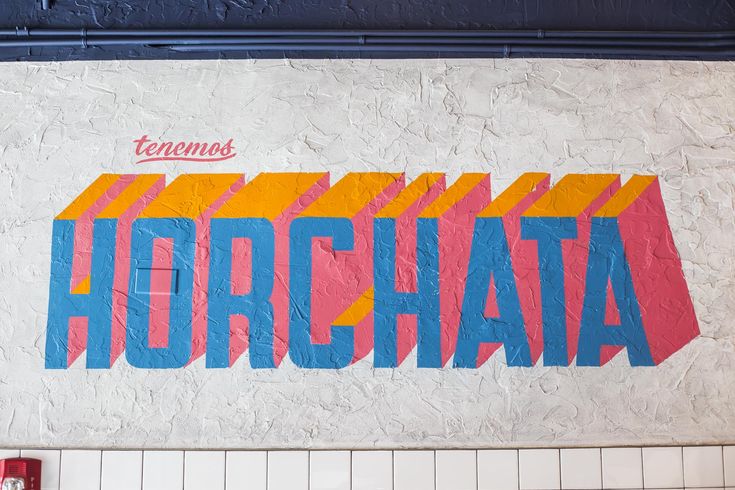 a mural on the side of a building that says horchata in bold colors