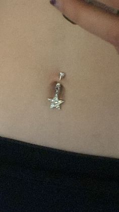 a woman's belly with a tiny star charm attached to the back of her stomach