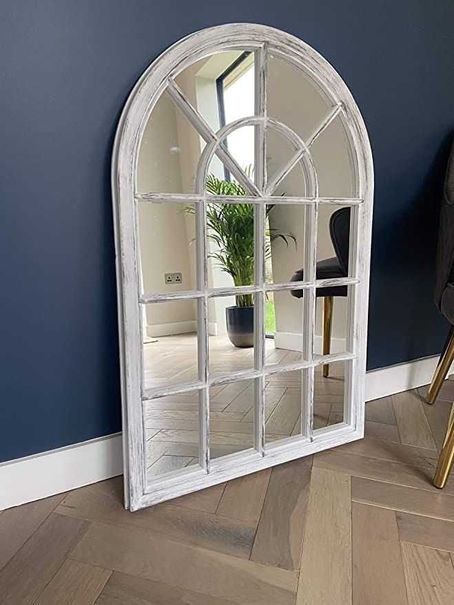 an arched window is shown in the middle of a room with blue walls and wood floors