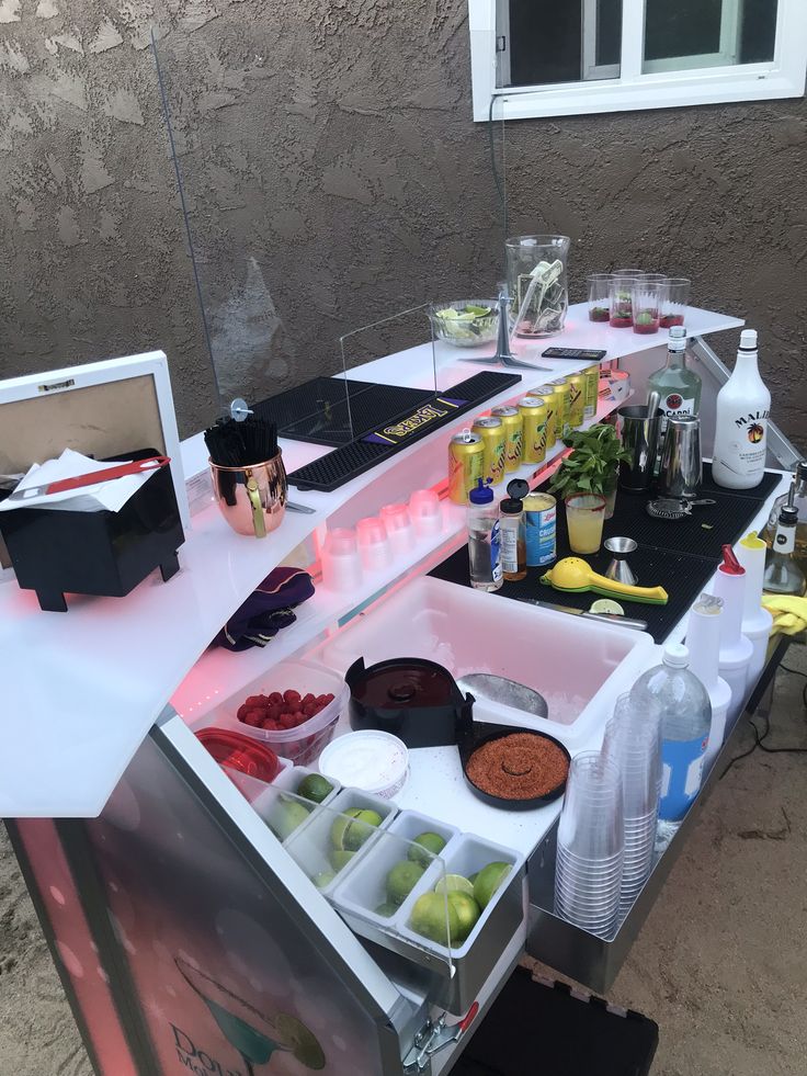 an outdoor bar is set up with drinks and condiments on the counter top