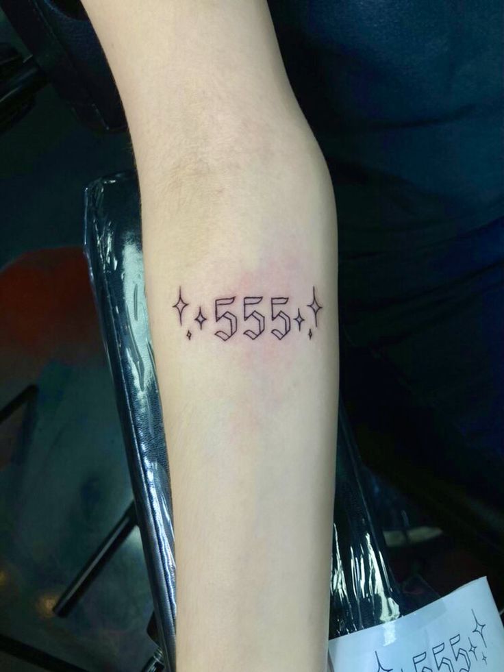 a person with a tattoo on their arm that has five stars and the number 55