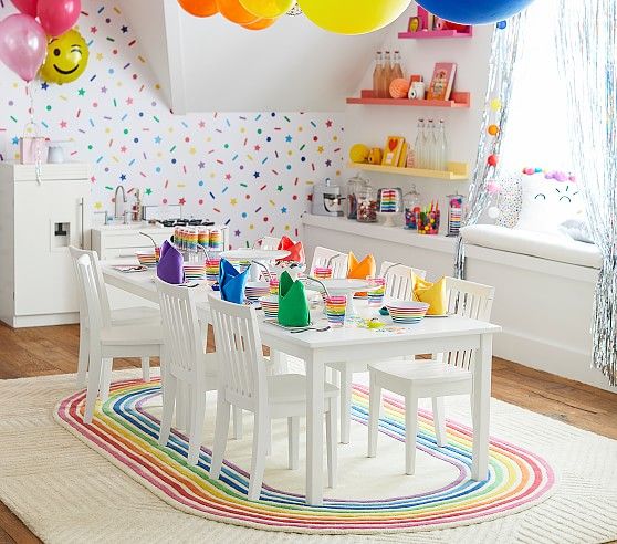 a child's birthday party with colorful balloons and table set for four, in the kitchen