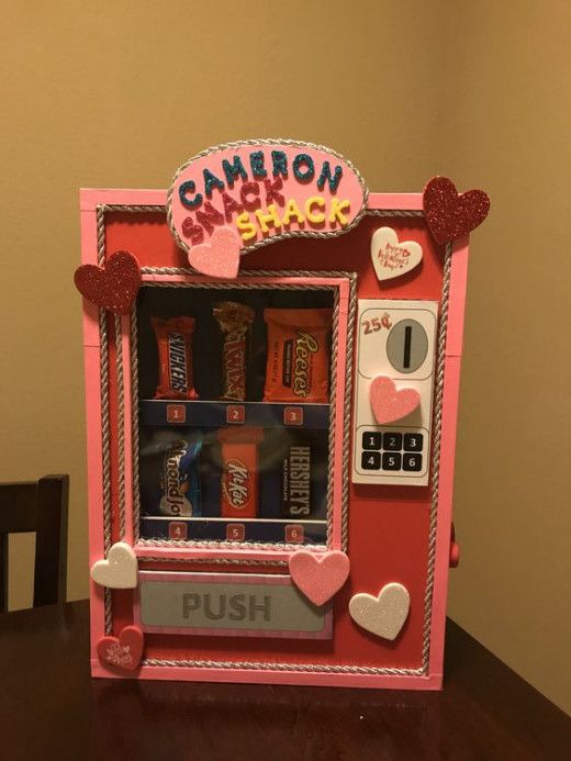 a pink candy machine sitting on top of a wooden table