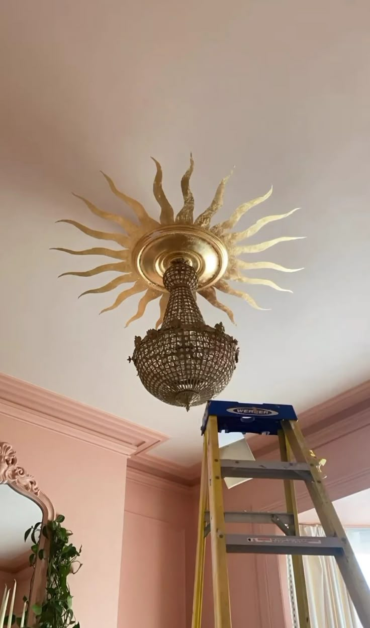 a light that is on top of a ladder in a room with pink walls and ceiling