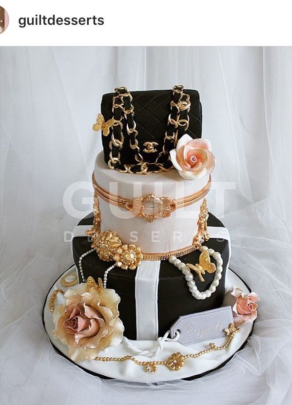 a three tiered cake is adorned with pearls, flowers and gold chains on top