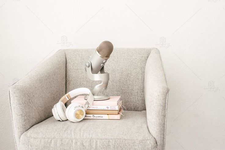 a chair with headphones and a microphone sitting on top of books in front of a white wall