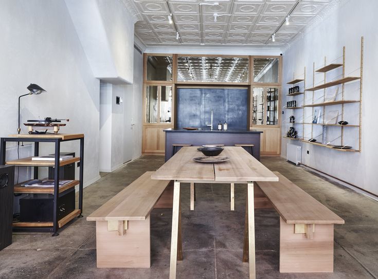 a large wooden table sitting in the middle of a room filled with shelves and furniture