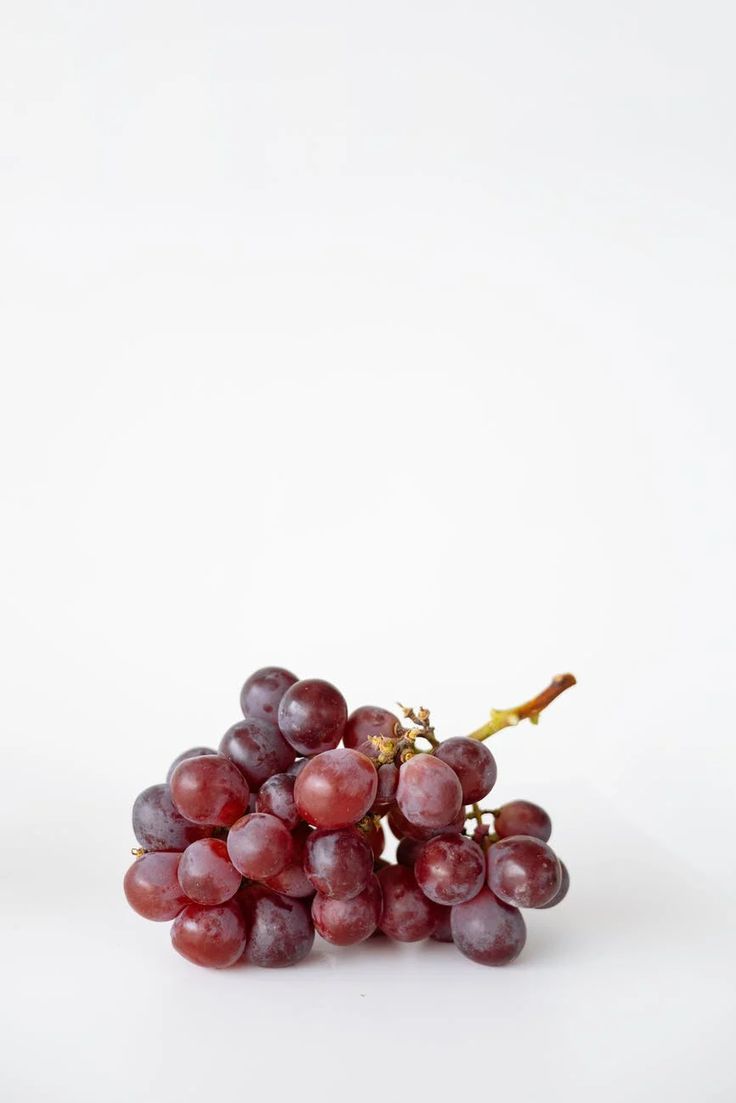 a bunch of grapes sitting on top of a white table