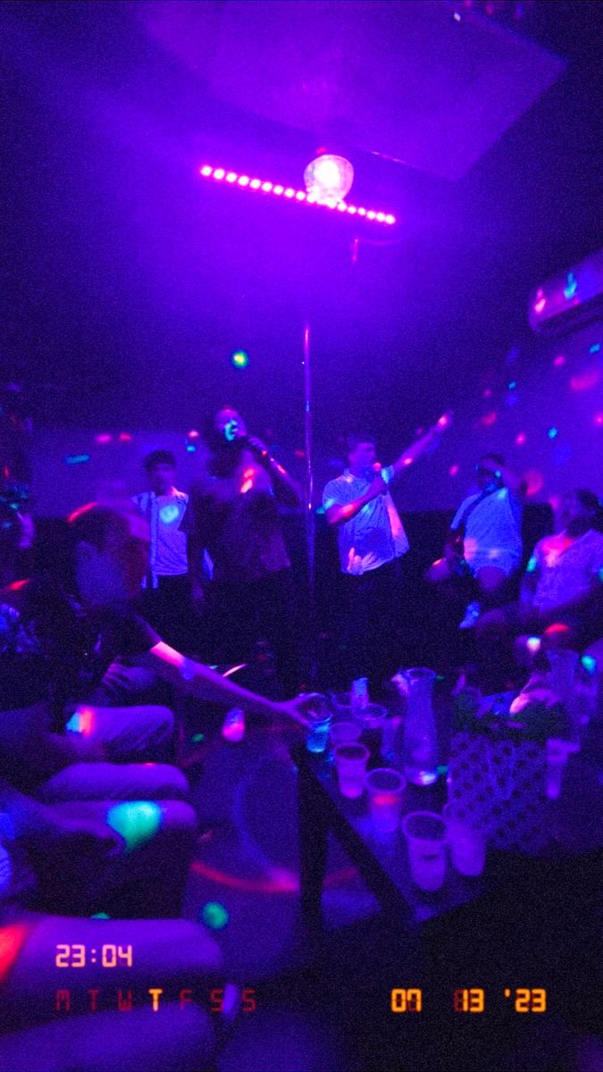 a group of people in a room with purple lights