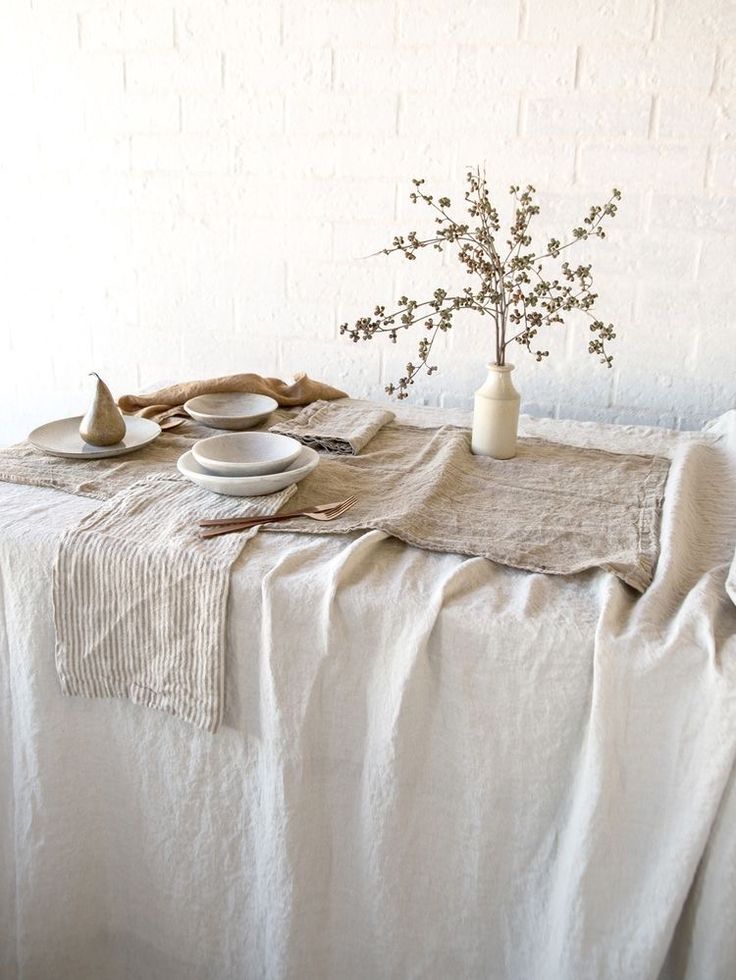 the table is set with white plates and silverware