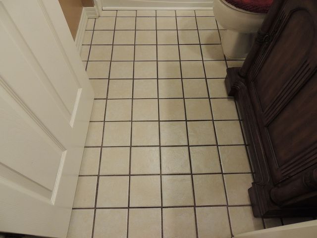 a white toilet sitting next to a bath tub in a bathroom on top of a tiled floor