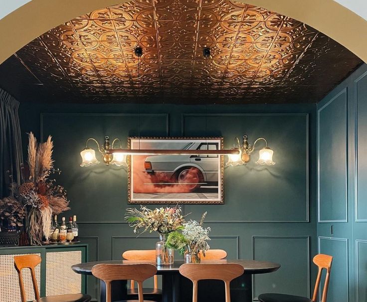 a dining room with green walls and wooden chairs