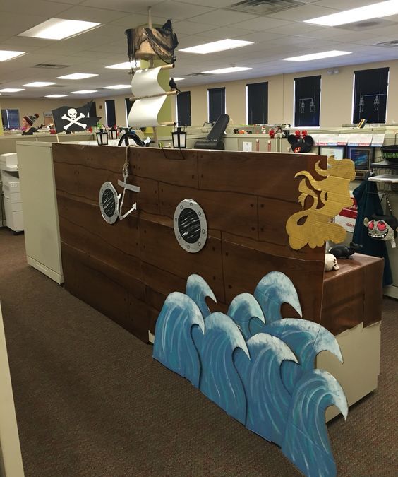 an office cubicle with a pirate ship painted on the wall and decorations around it