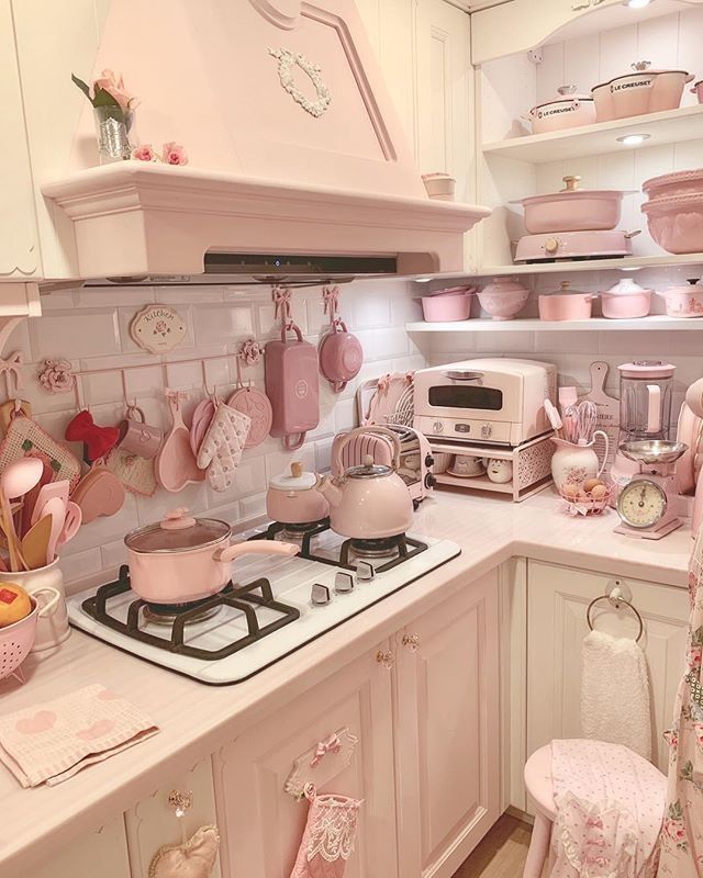 a kitchen filled with lots of pink pots and pans on top of a stove