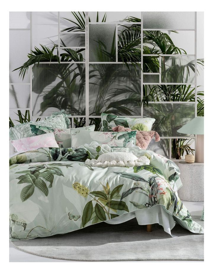 an image of a bedroom setting with plants on the wall and bedding in it