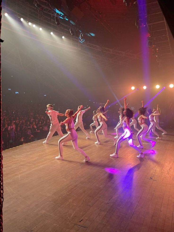 a group of dancers performing on stage in front of an audience