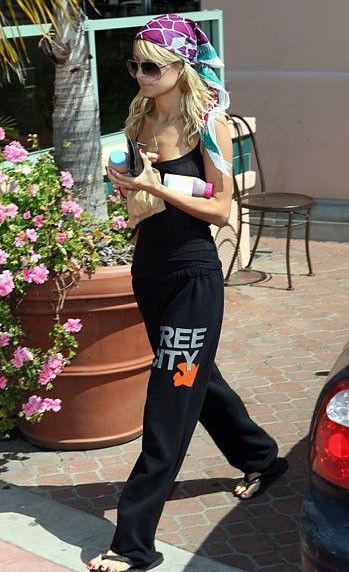 a woman is walking down the street with her cell phone