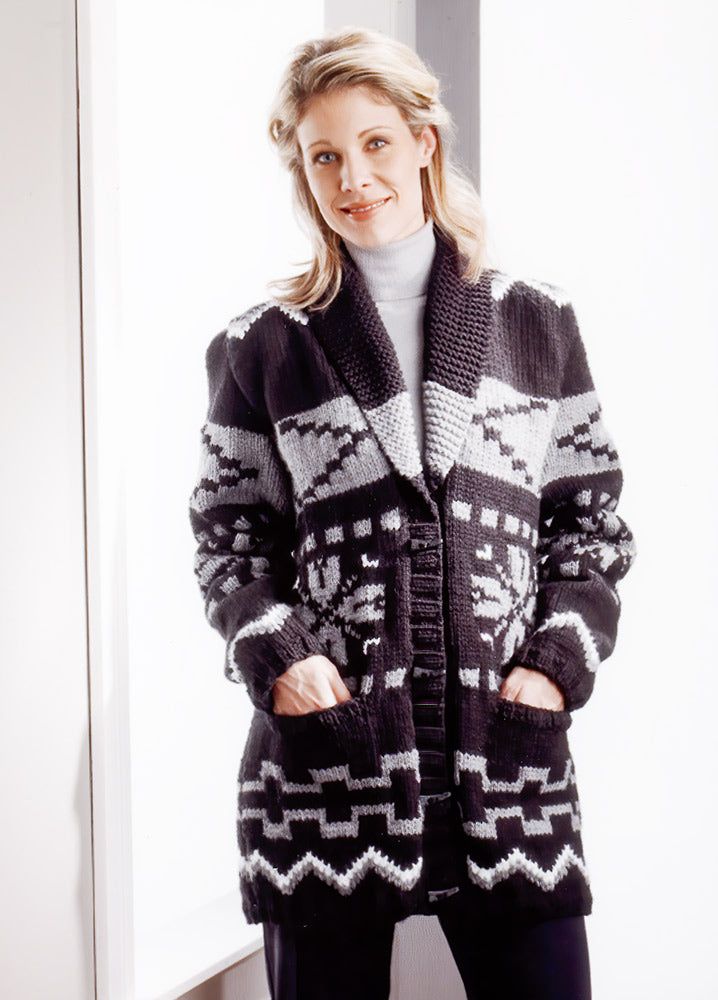 a woman standing in front of a window wearing a black and white knitted cardigan