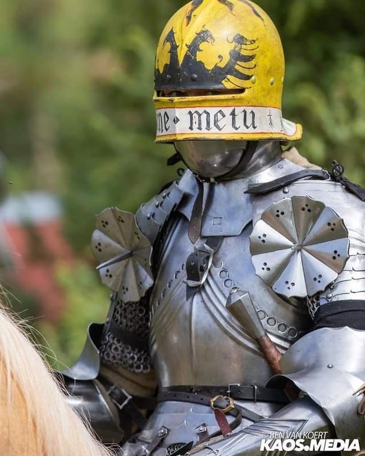 a man in armor riding on the back of a horse